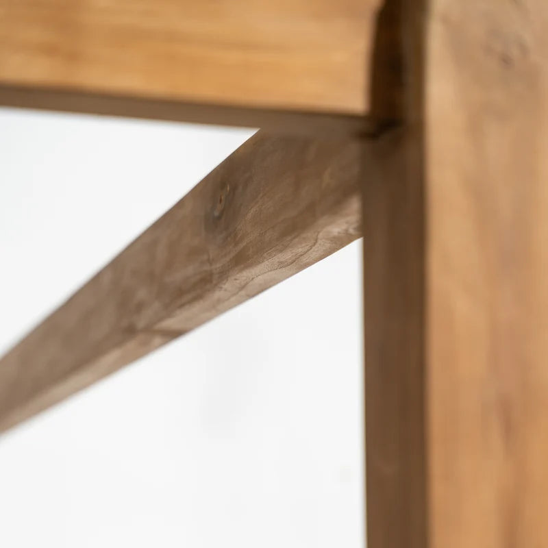 Close-up detail of a wooden furniture frame showing natural wood grain, knots, and a clean white background.