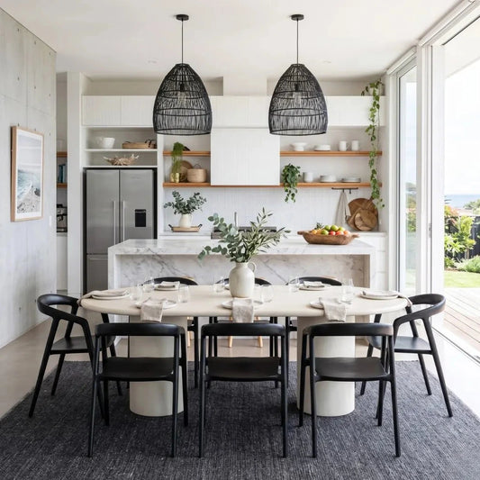 Modern kitchen with dining table and chairs, marble island, and large windows.