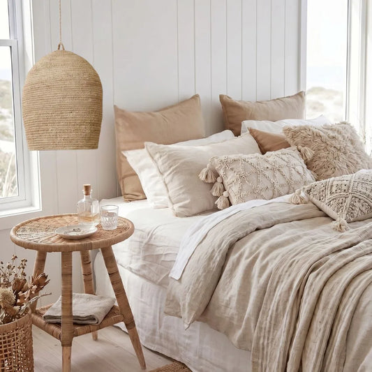 Cozy bedroom with a bed adorned with pillows, a wooden side table, and a woven lamp.
