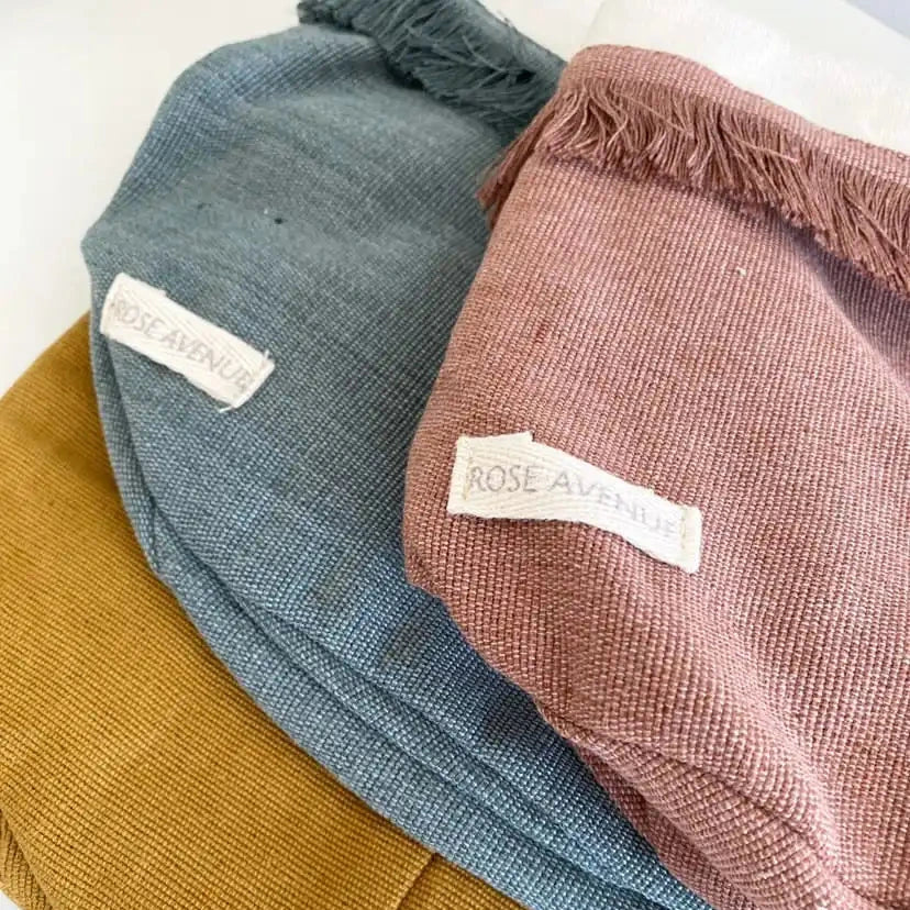 Three textured hats in blue, brown, and pink with 'Rose Avenue' labels on a white background.