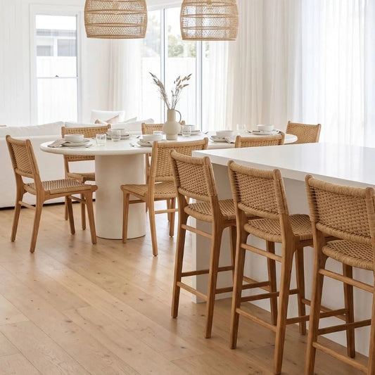 Modern kitchen with wooden chairs around a dining table and island.