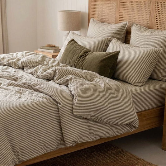 Bedroom with wooden bed, striped bedding, and wicker headboard.