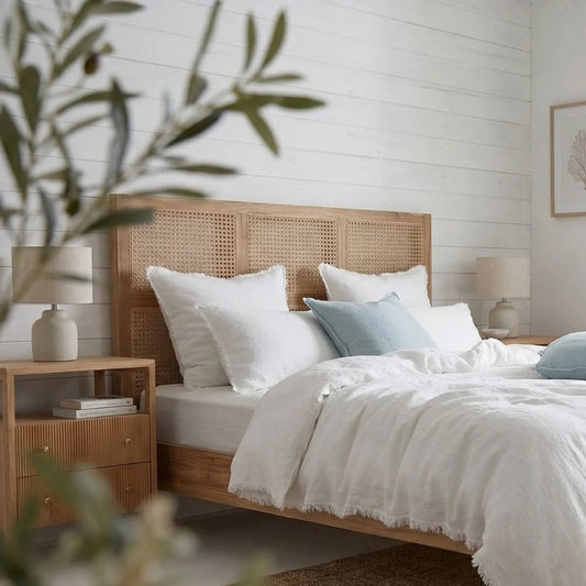Bedroom with wooden headboard, white bedding, and nightstands with lamps.