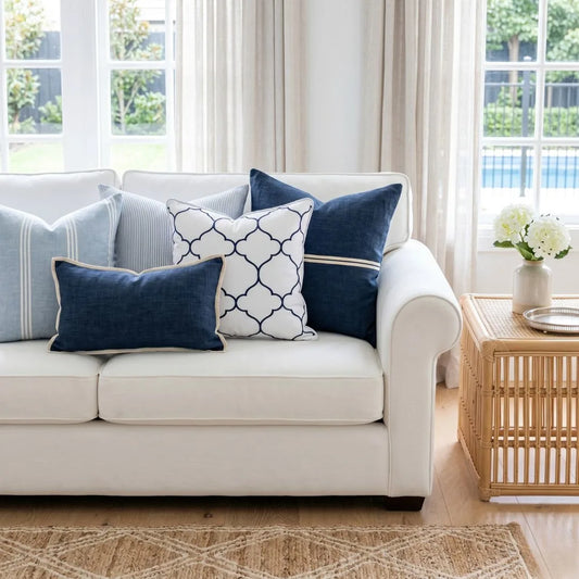 White sofa with blue and patterned cushions in a bright living room.