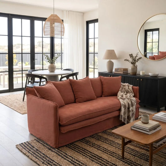 Living room with a linen desert rose colour sofa,, coffee table, and decorative items.