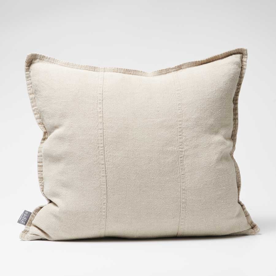 Beige pillow with brown trim on a white background
