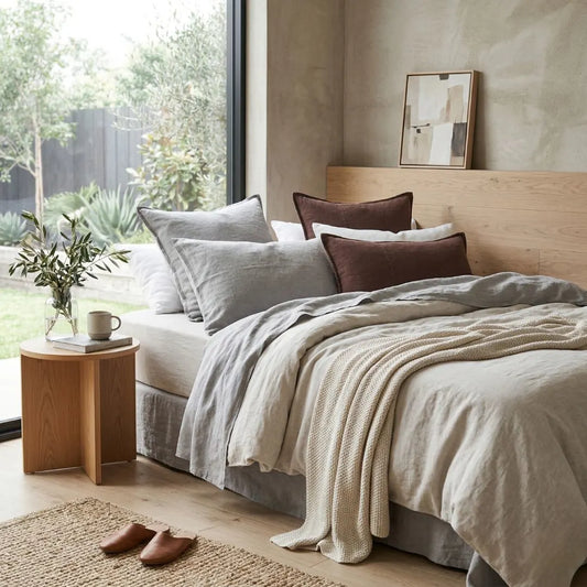 Neatly made bed with pillows and a blanket in a bedroom setting.