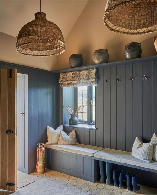 Nook with wooden bench, decorative pillows, and hanging wicker lights.