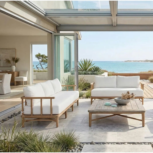 Outdoor patio with white cushioned furniture and a view of the ocean.