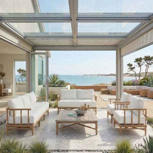 Modern outdoor patio with white furniture and a view of the ocean.