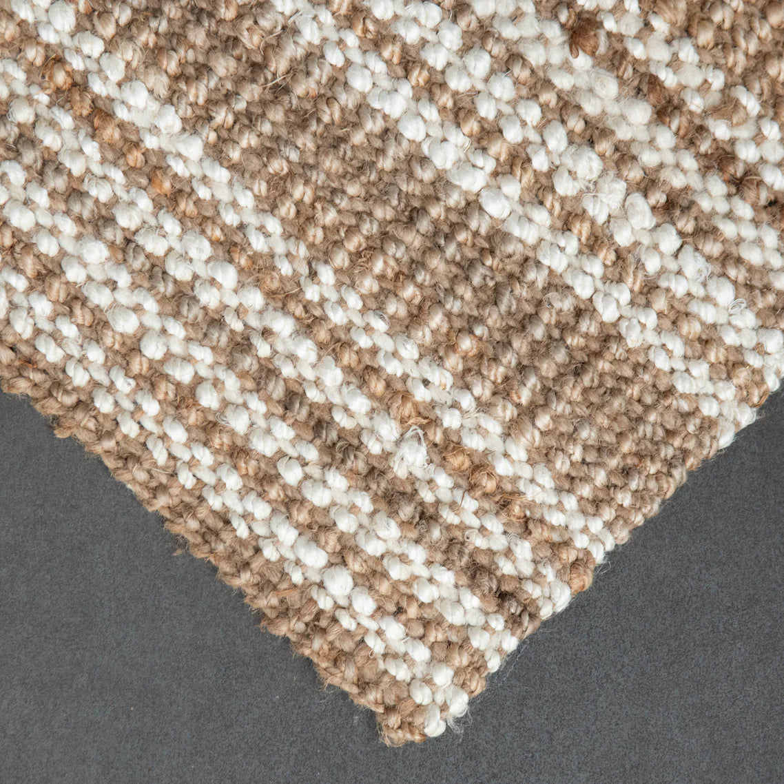 Close-up of a textured beige and white carpet corner