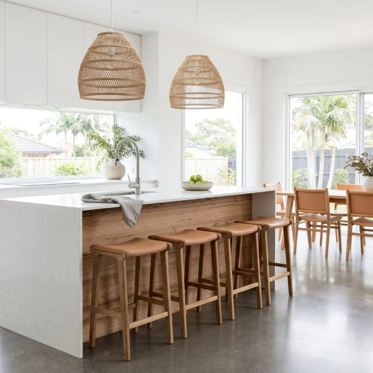 Sun Republic Natural Tan Leather and Teak stools in front of a kitchen counter in a modern open plan kitchen and dining room