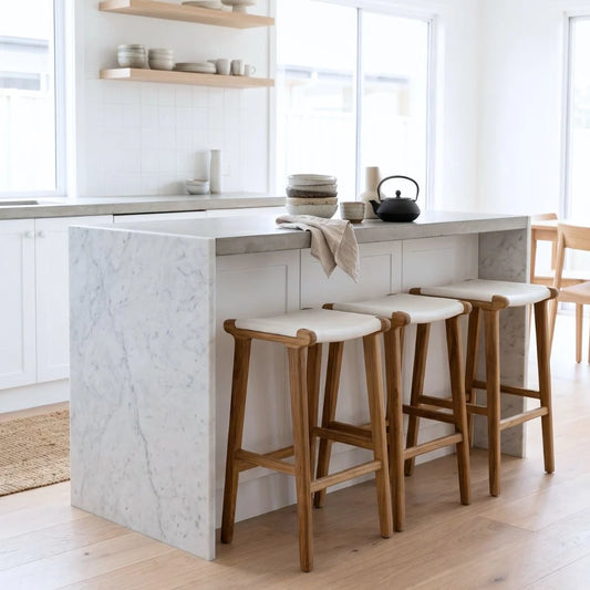 Modern kitchen with white island bench with white leather and teak counter stools