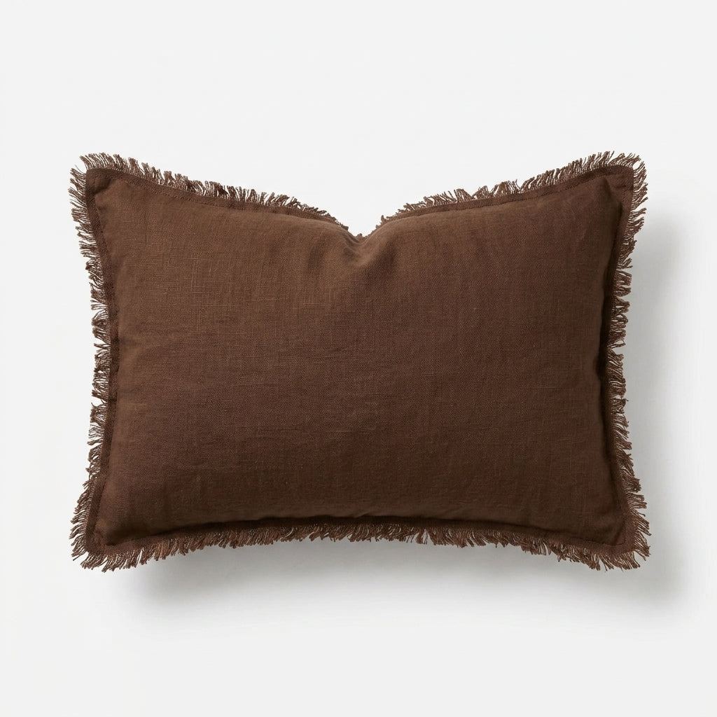A rectangular brown linen throw pillow with fringed edges, shown against a clean white background.