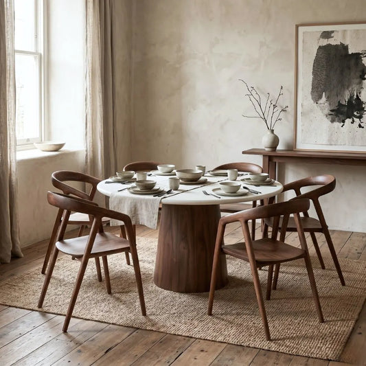 Dining room with a round wooden table and chairs, set for a meal.