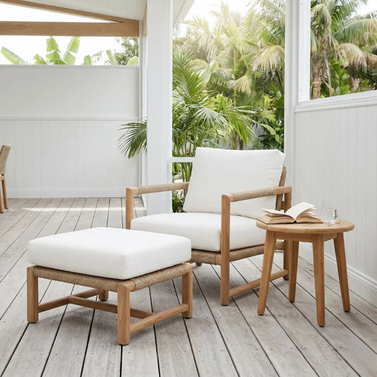 Wooden outdoor furniture set with white cushions on a wooden deck.