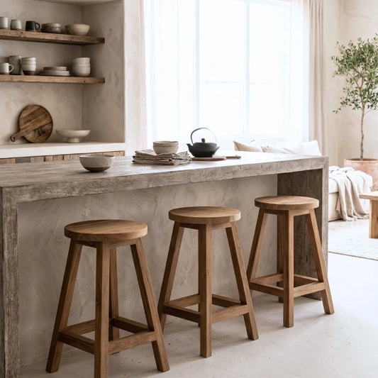 Sun Republic round teak counter stool in a row of three at a kitchen island bench in a modern rustic kitchen