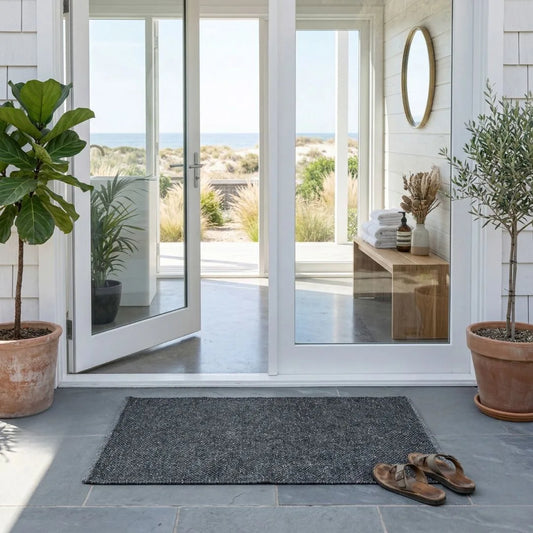Modern exterior with sliding glass door leading to outdoor patio, plants, and a eco doormat.
