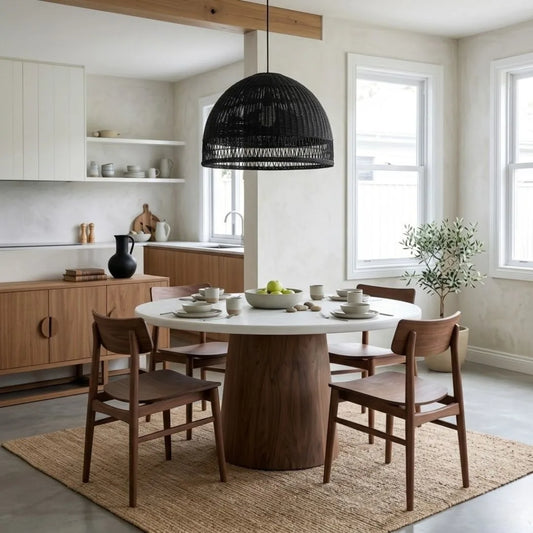 Jansen microcement round dining table with walnut base, matching walnut jansen dining chairs in a modern home.