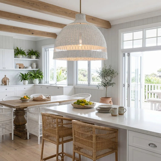 Modern kitchen with white countertops, wooden dining table, and wicker chairs.