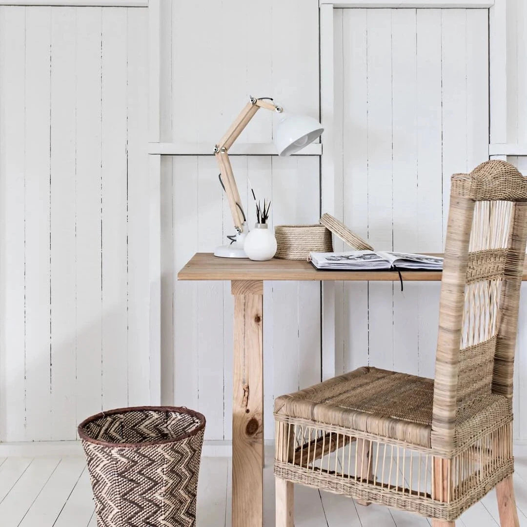 Small wooden desk with a chair against a white paneled wall