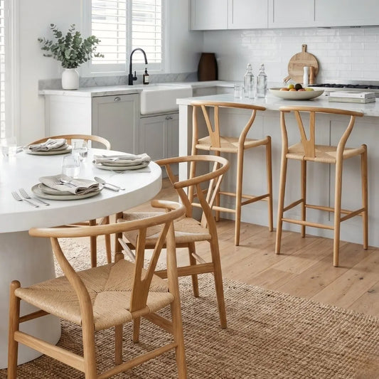 Kitchen with wooden chairs around a dining table, kitchen counter, and appliances.