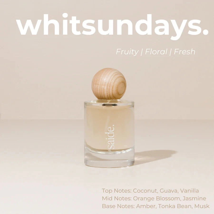 Perfume bottle with wooden cap on a beige background, featuring the brand 'whitsundays'.