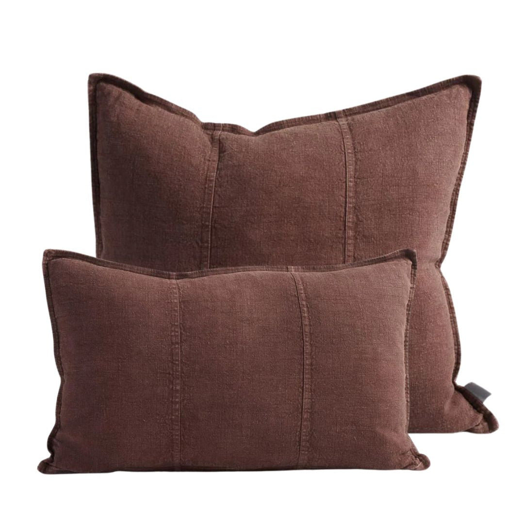 Two chocolate brown pillows on a white background