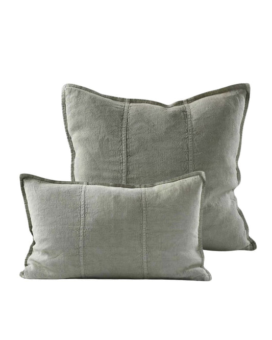 Two green pillows with textured edges on a white background