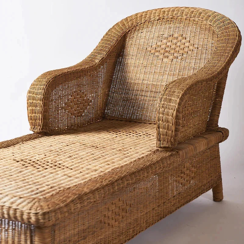 Close up of a Woven cane sunlounge chair on a plain background