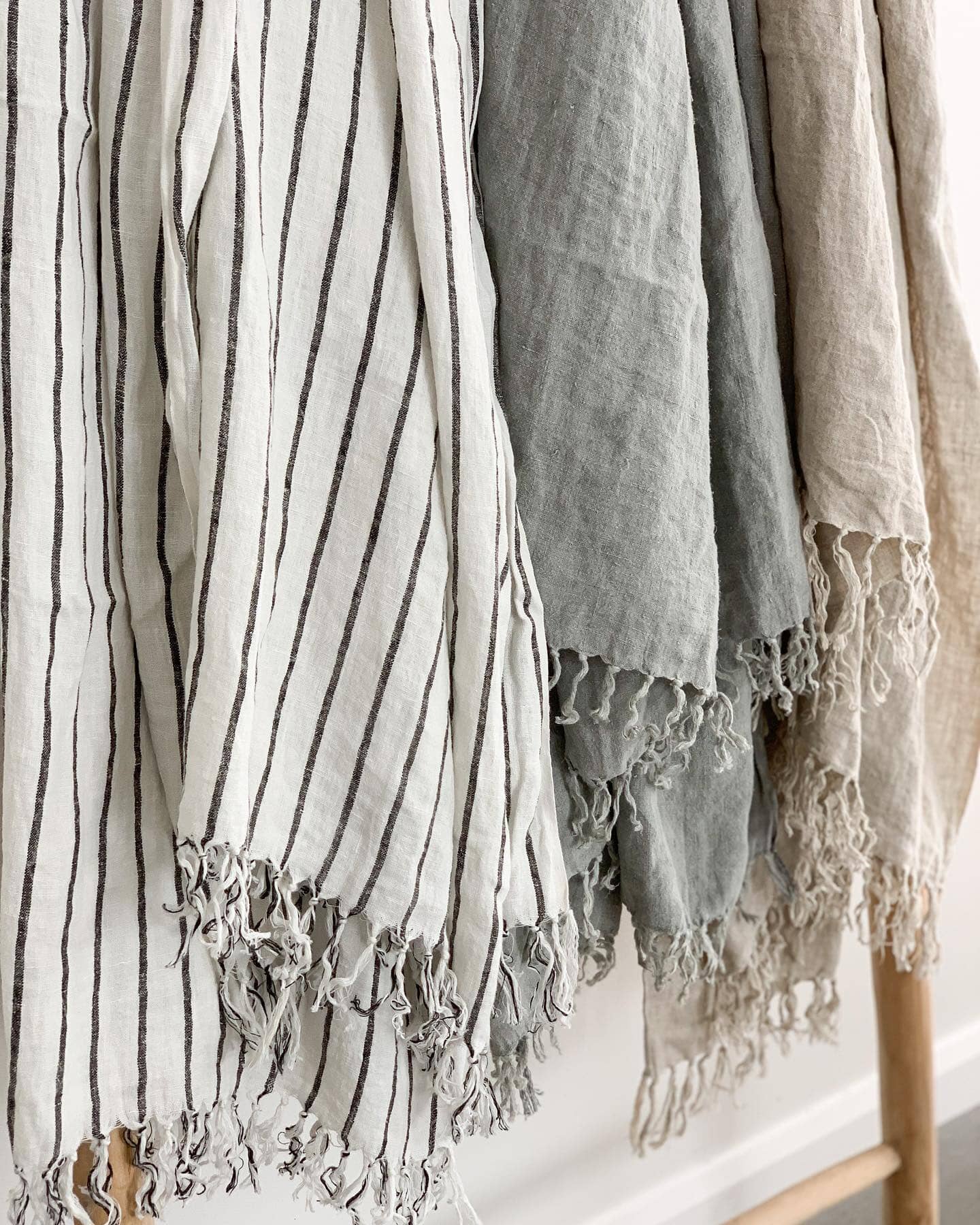 Textured fabric with lace trim draped over a wooden stand.