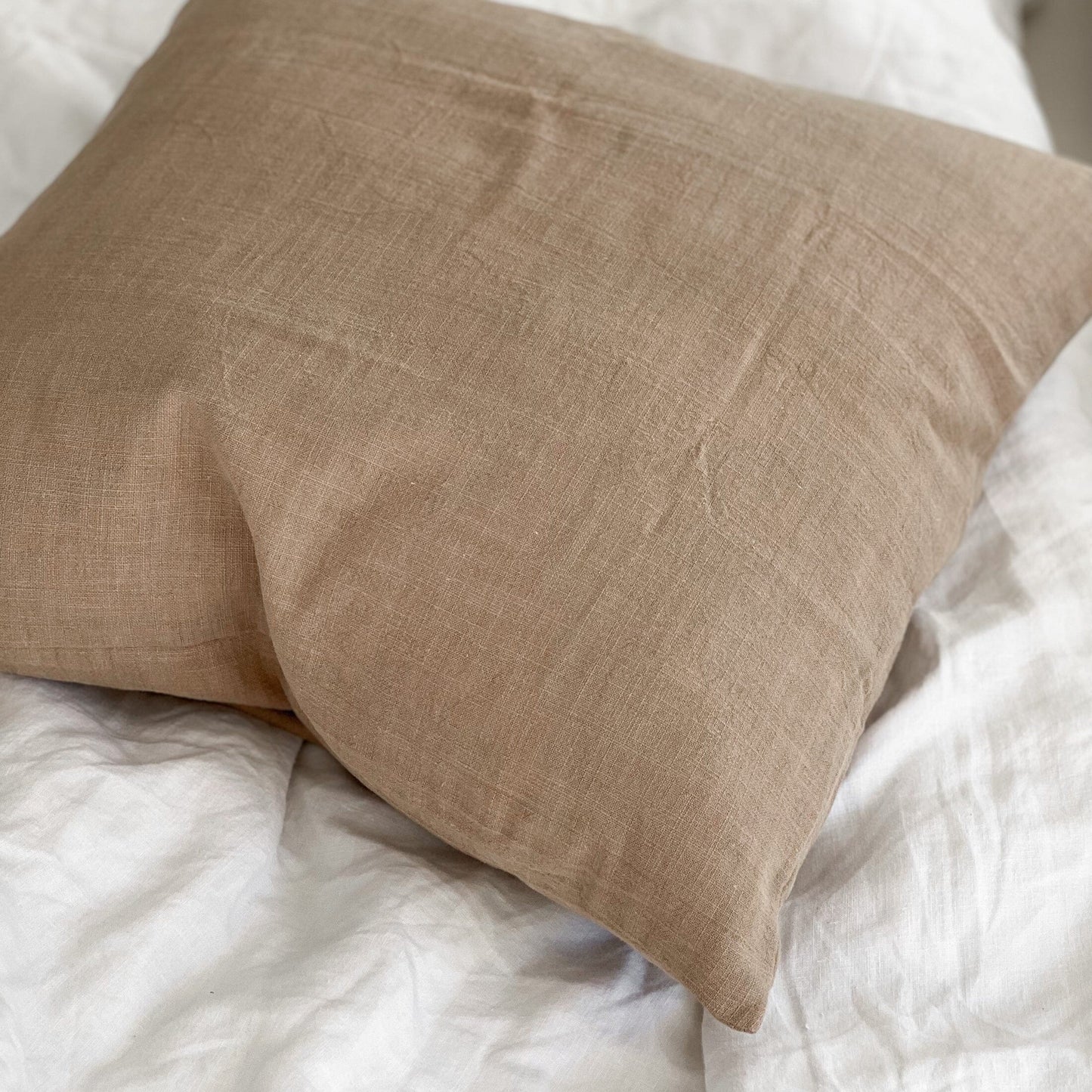 Brown pillow on a white textured surface