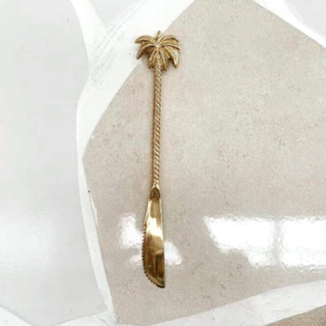 Gold knife with palm tree design on a white background