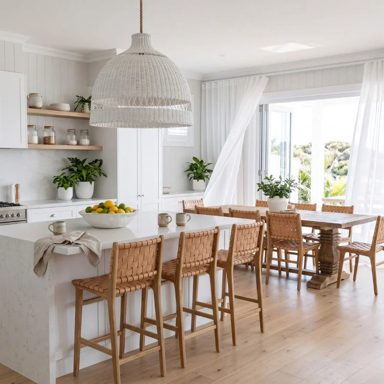 Modern kitchen with white island, wooden chairs, and large windows.