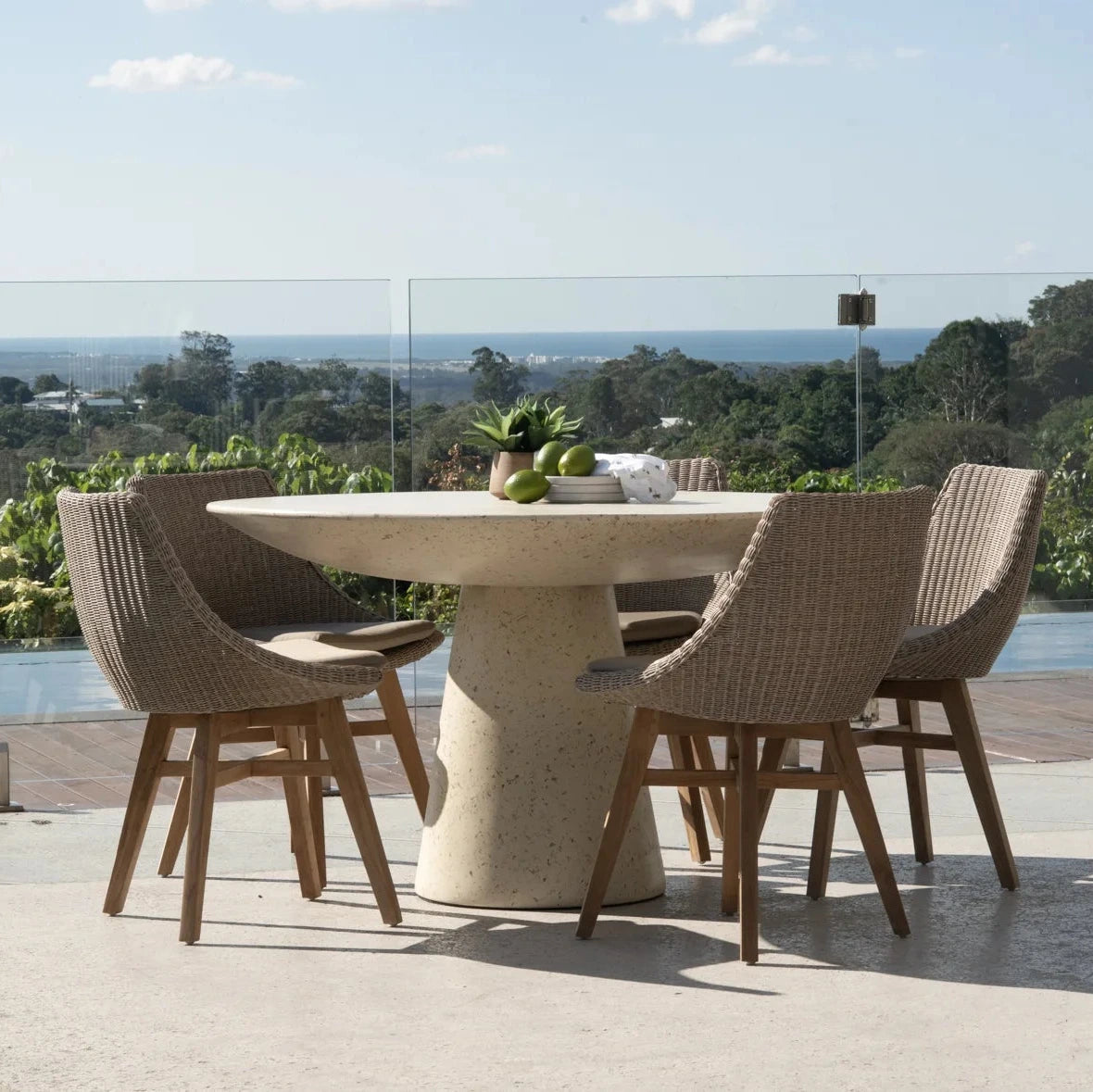 Dining table with chairs on a patio overlooking a scenic view
