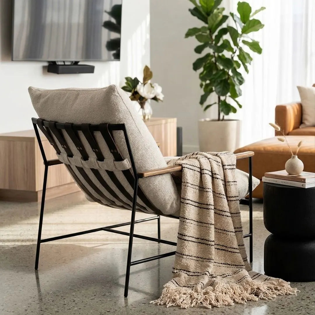 Modern chair with a blanket and pillow in a living room setting