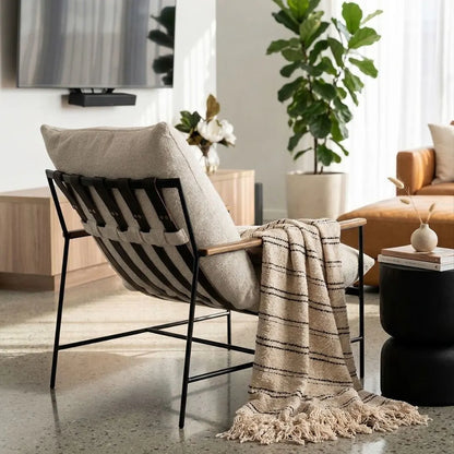 Modern chair with a blanket and pillow in a living room setting