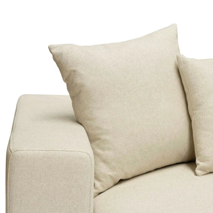 Beige sofa with two pillows on a white background