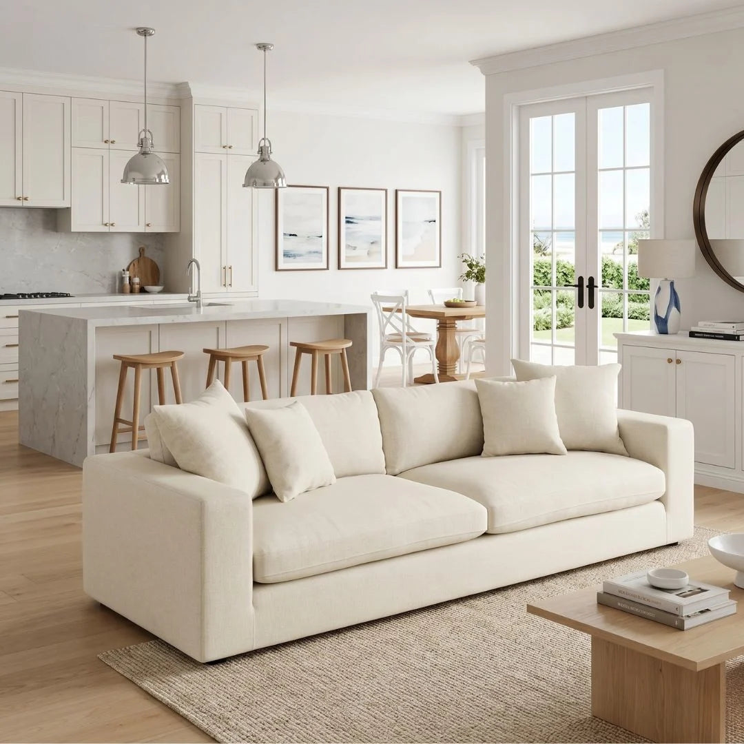 Modern living room with a white sofa, kitchen in the background