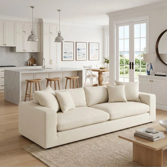 Modern living room with a white sofa, kitchen in the background