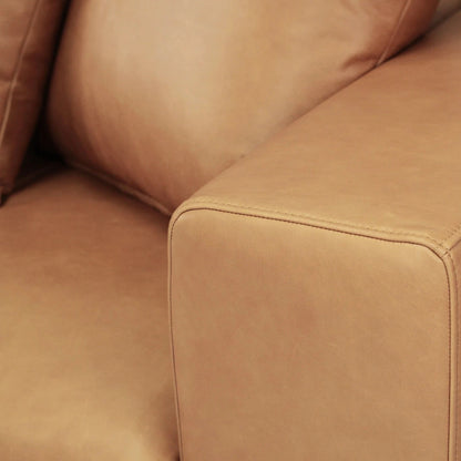 Close-up of a tan brown leather sofa corner