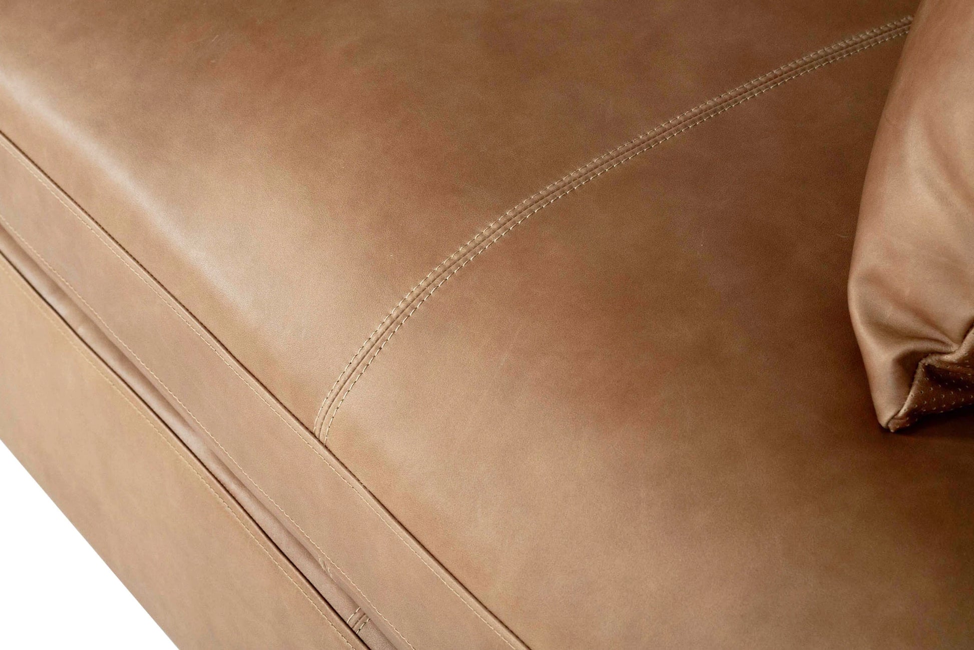 Close-up of a brown leather sofa with visible stitching