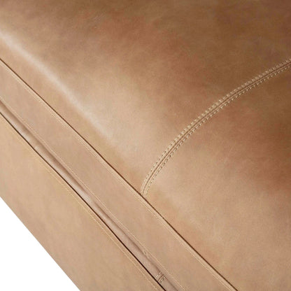 Close-up of a brown leather sofa with visible stitching