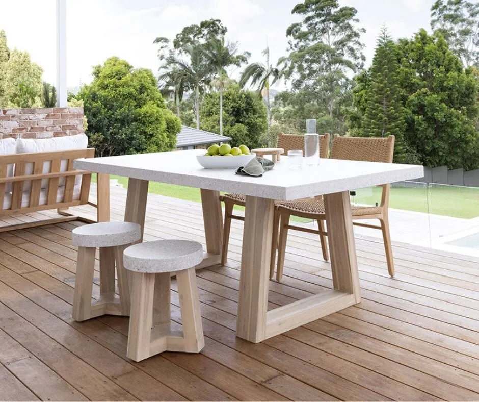 Outdoor dining set with a table, chairs and stools on a wooden deck.