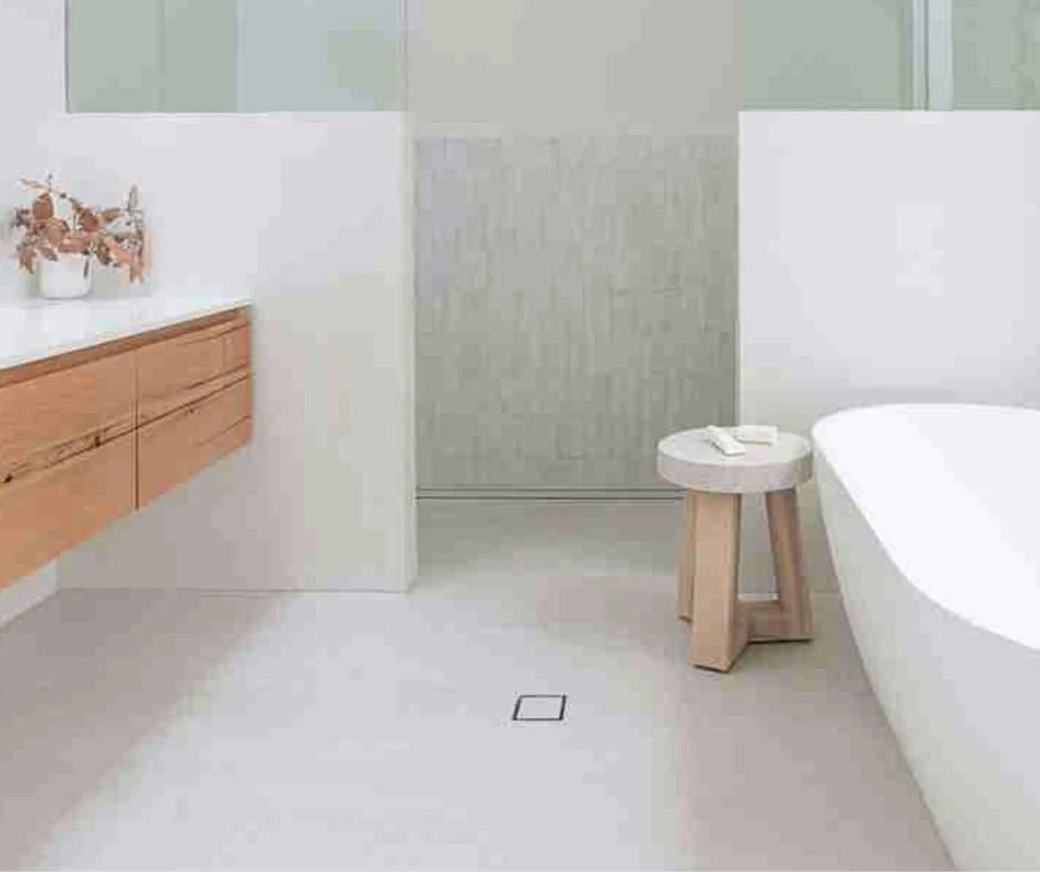 Modern bathroom with wooden vanity, white bathtub, and small stool.