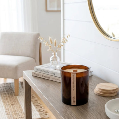 Candle on a wooden table with books and decor in a bright room