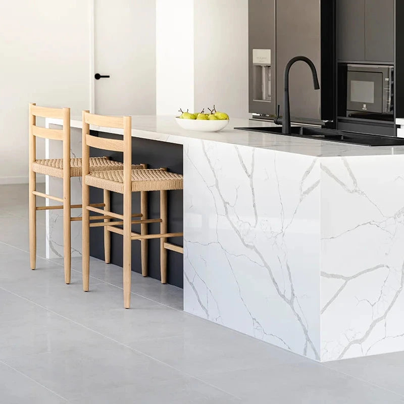 Modern kitchen with white marble island and wooden chairs