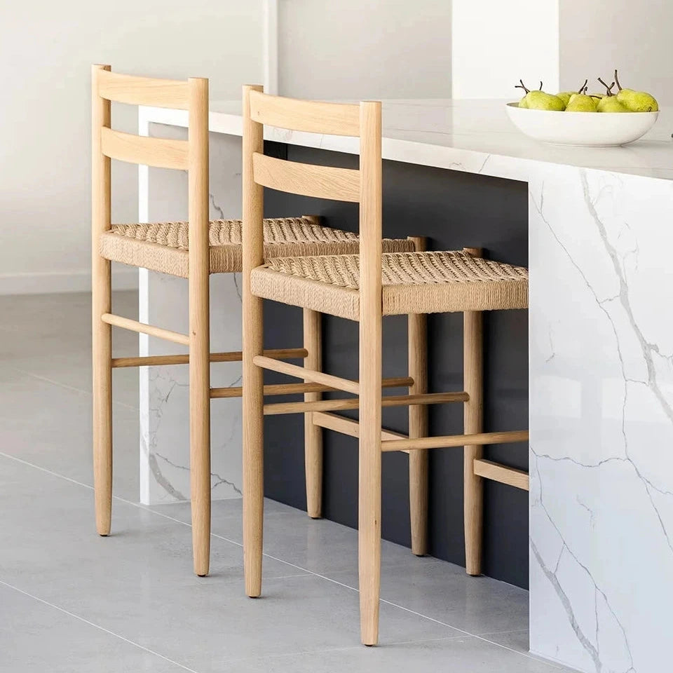 Two wooden bar stools with woven seats in a modern kitchen.