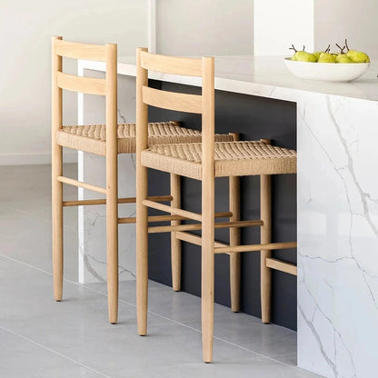Two wooden bar stools with woven seats in a modern kitchen.