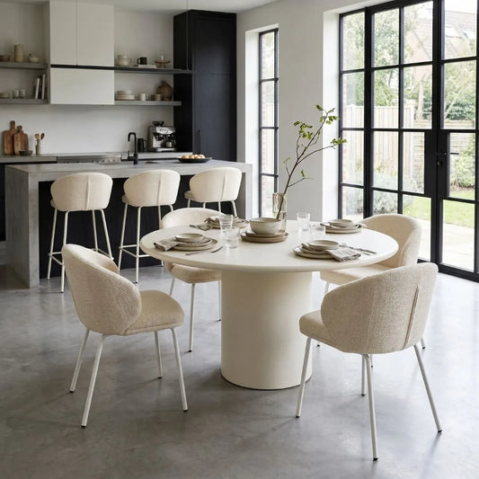Modern kitchen with a round dining table and chairs near a kitchen island.
